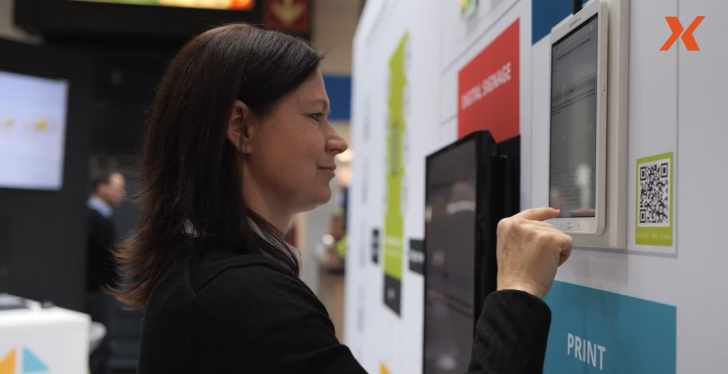 A woman uses a touch screen on a trade fair.