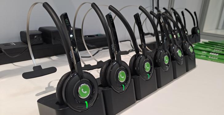 Various headsets lined up on charging stations.