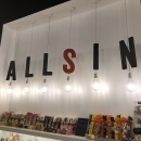 A shelf with sweets, above the letters of the company name with light bulbs...