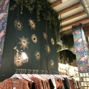 A clothing store with ivy hanging from the ceiling