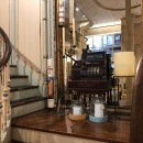 A historical staircase in a building, on the landing a historical cash register...