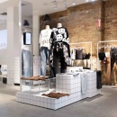 A modern design fashion pop-up store with mannequins standing on white tiled...