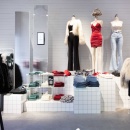 A modern design fashion pop-up store with mannequins standing on white tiled...