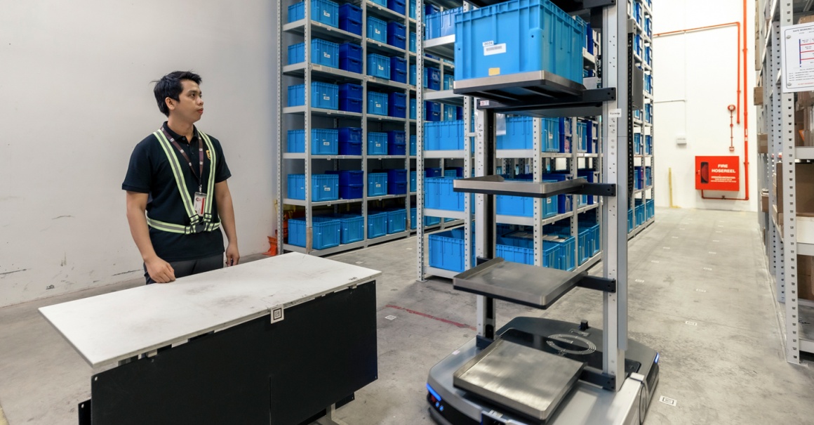 A man standing at a table inside a storage hall