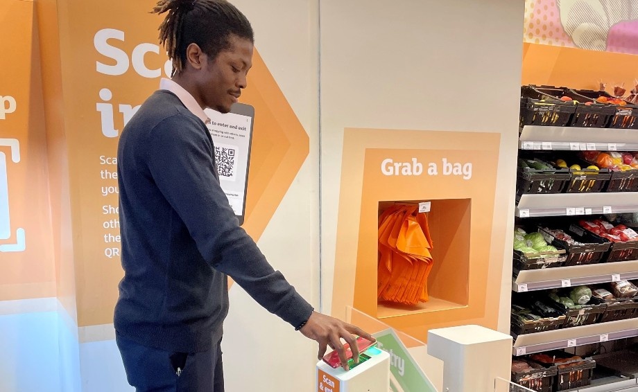 A man using his smartphone to check in at Sainsburys...