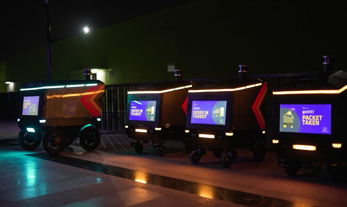 autonomous delivery robots standing on a dark street...