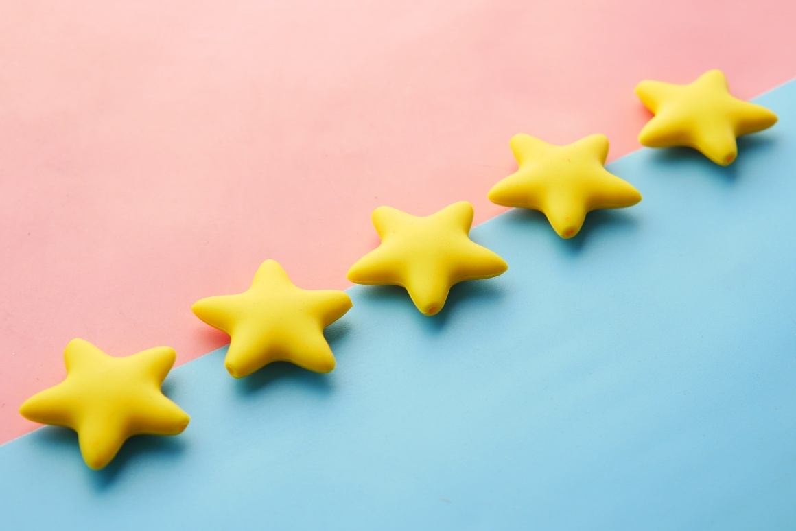 Five yellow stars on a pink and blue background