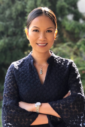 A woman with folded arms smiles at the camera