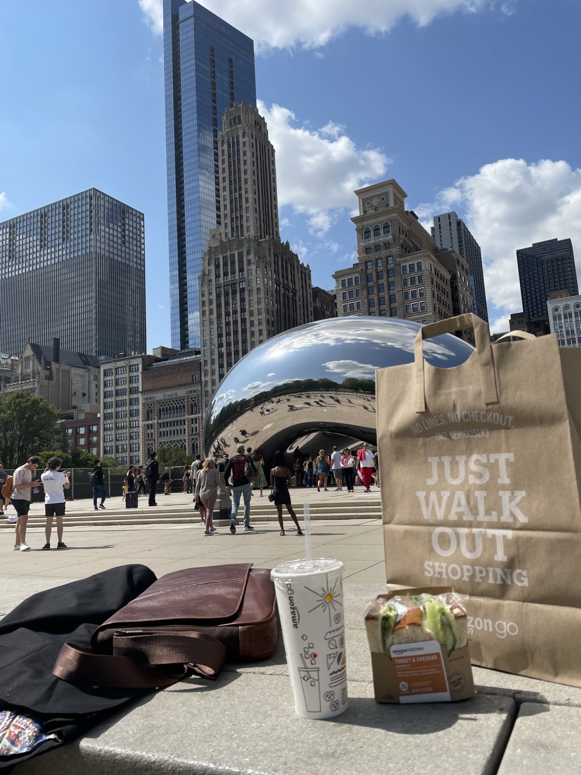 An Amazon Go bag, a drink and a handbag on a square in front of the Chicago...