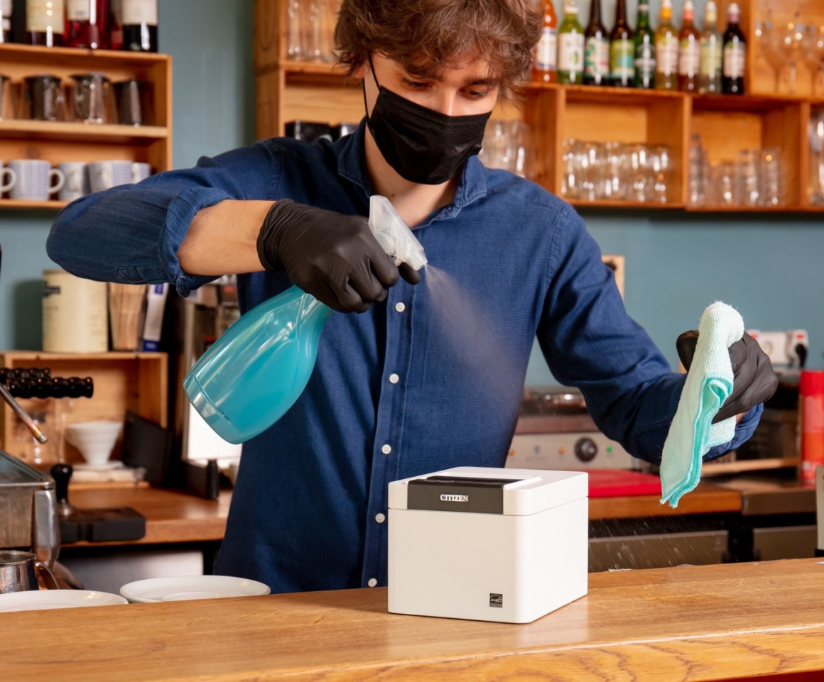 a man cleaning a POS-printer; Copyright: Citizen Systems Europe...