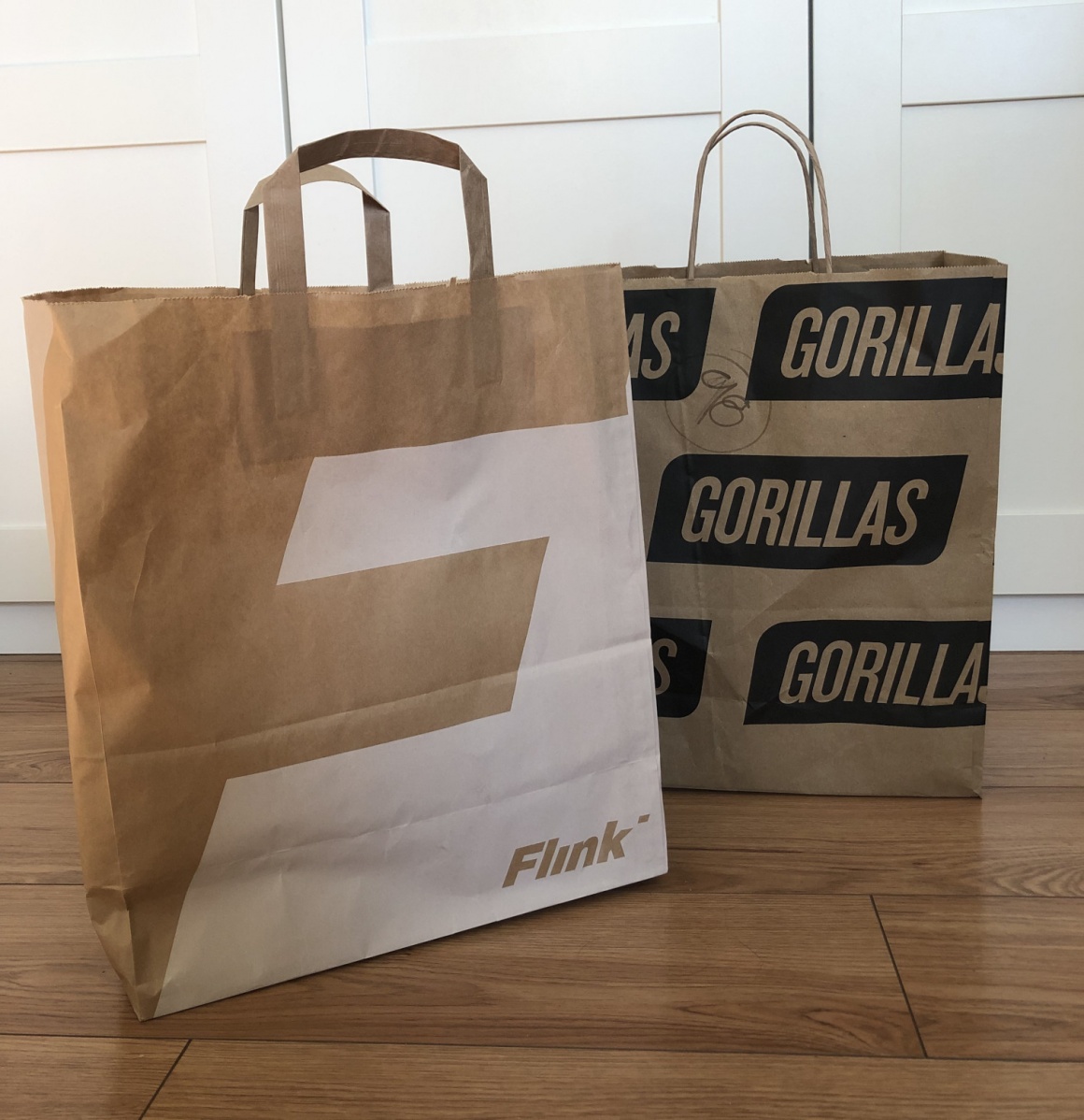 Two paper bags side by side, one from Flink, one from Gorillas...