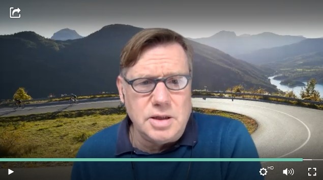 A man at a webtalk, a street and mountains as a virtual background...