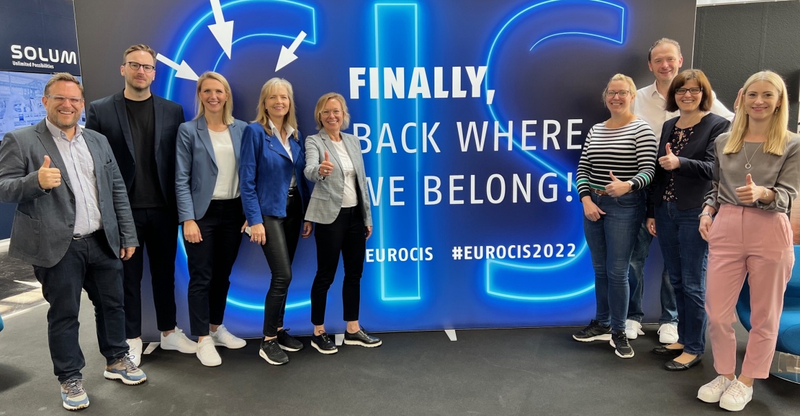 The EuroCIS 2022 team in front of a wall with the inscription Finally back...