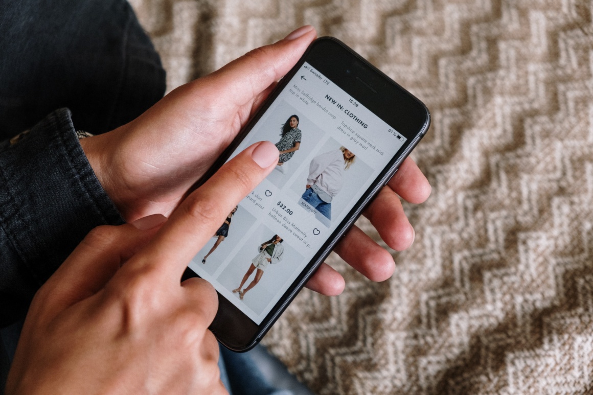 A person is using a smartphone to shop clothes online...