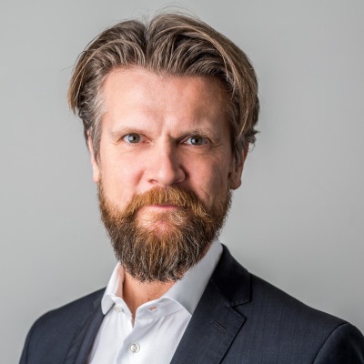 Man with beard in suit looks at camera