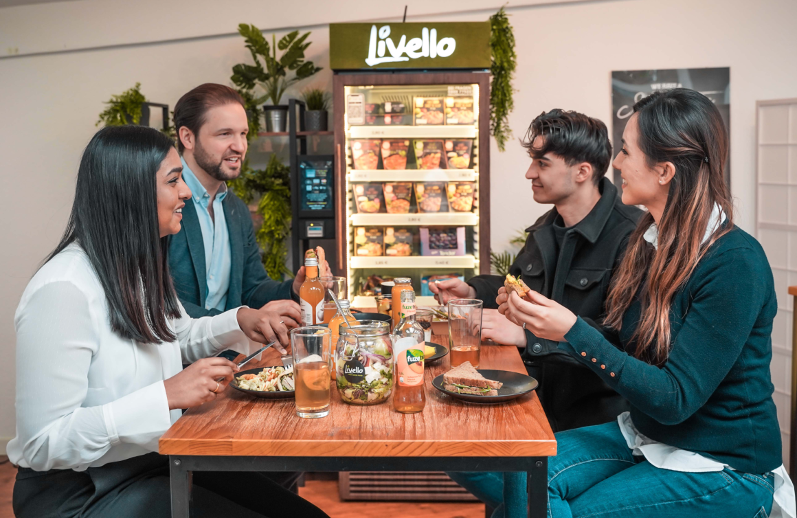 Alexander Eissing at the table with employees, in the background a vending...