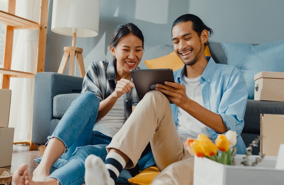 Two people smiling and looking at a tablet