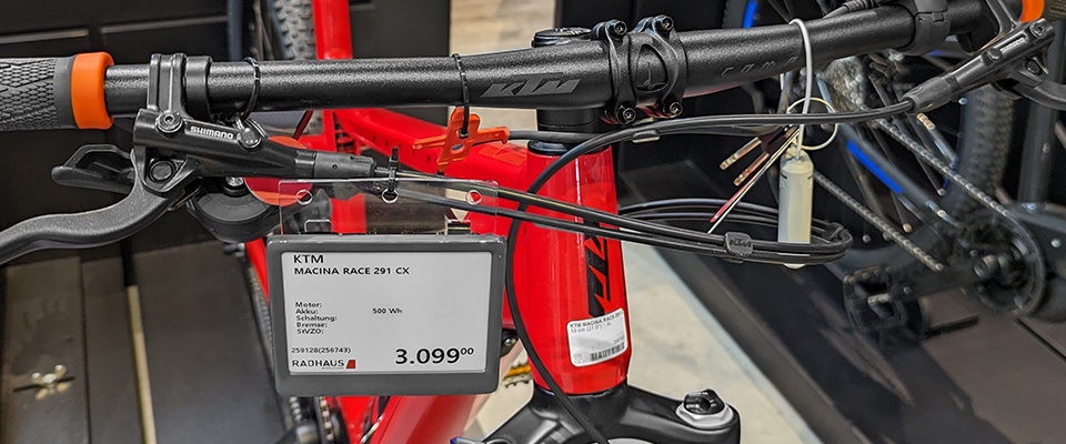 An electronic shelf label hangs on a red bike