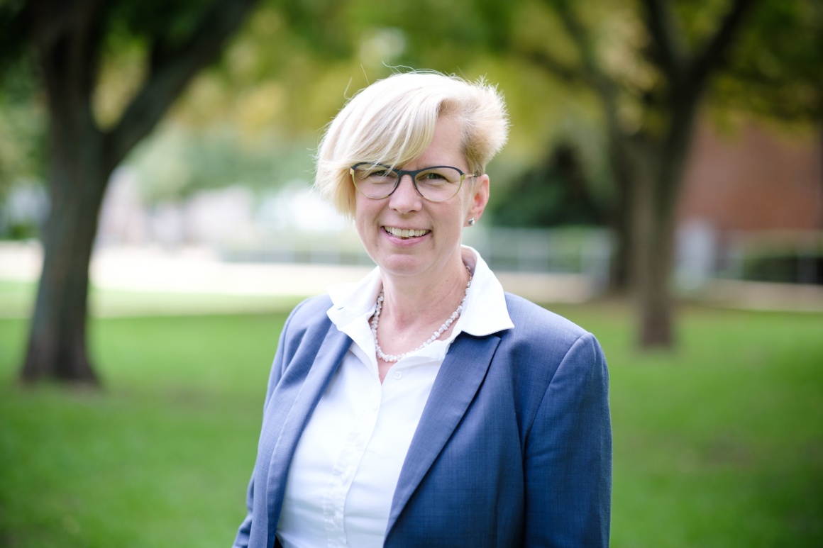 Woman with blond hair and glasses looks into the camera...