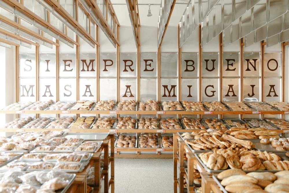 A counter display in a bakery with many different breads and buns...