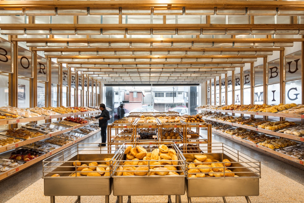 A counter display in a bakery with many different breads and buns...