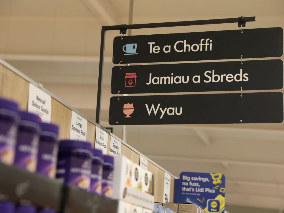 Three signs with Welsh language on them in a store