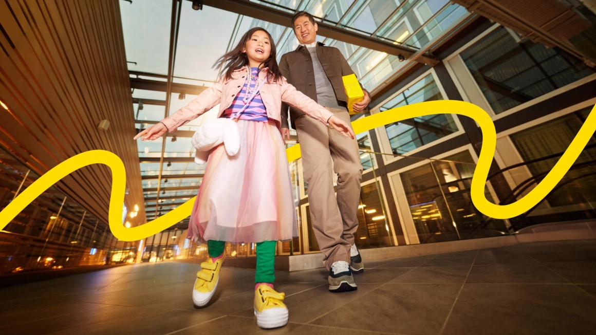 A child and an adult walk through a shopping centre...