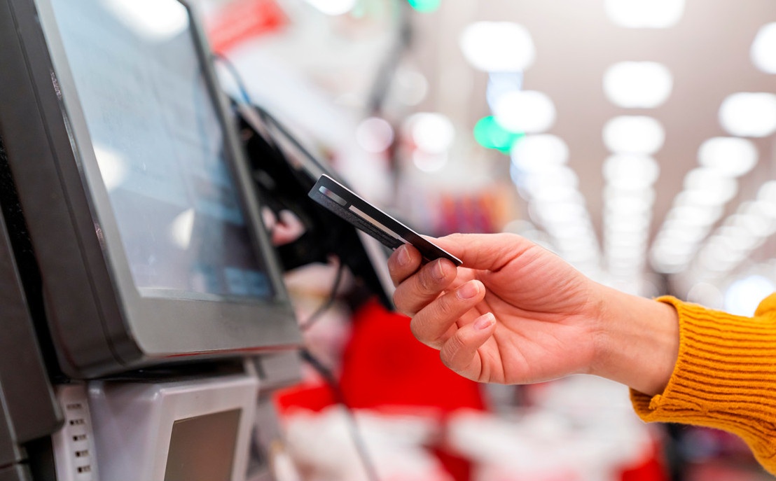 A hand inserts a check card into a reader