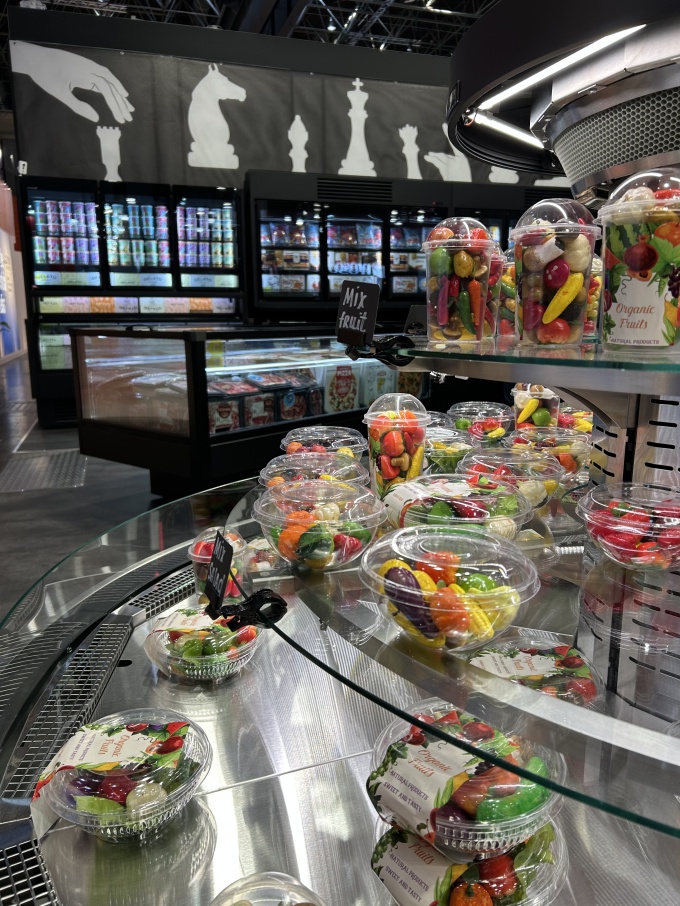 An open, multi-tiered display case showcases packaged fresh produce....