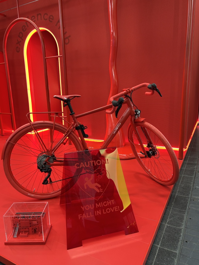 A red bicycle in a red setting with a red sign