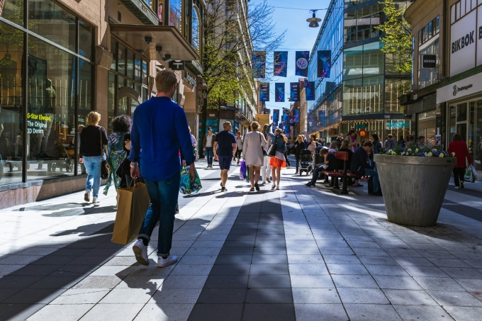 A modern pedestrian zone with trees and tall buildings...