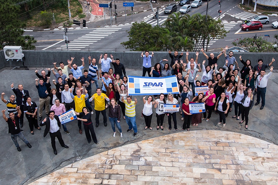 Employees of the new SPAR Brazil welcome the new company outside their offices...