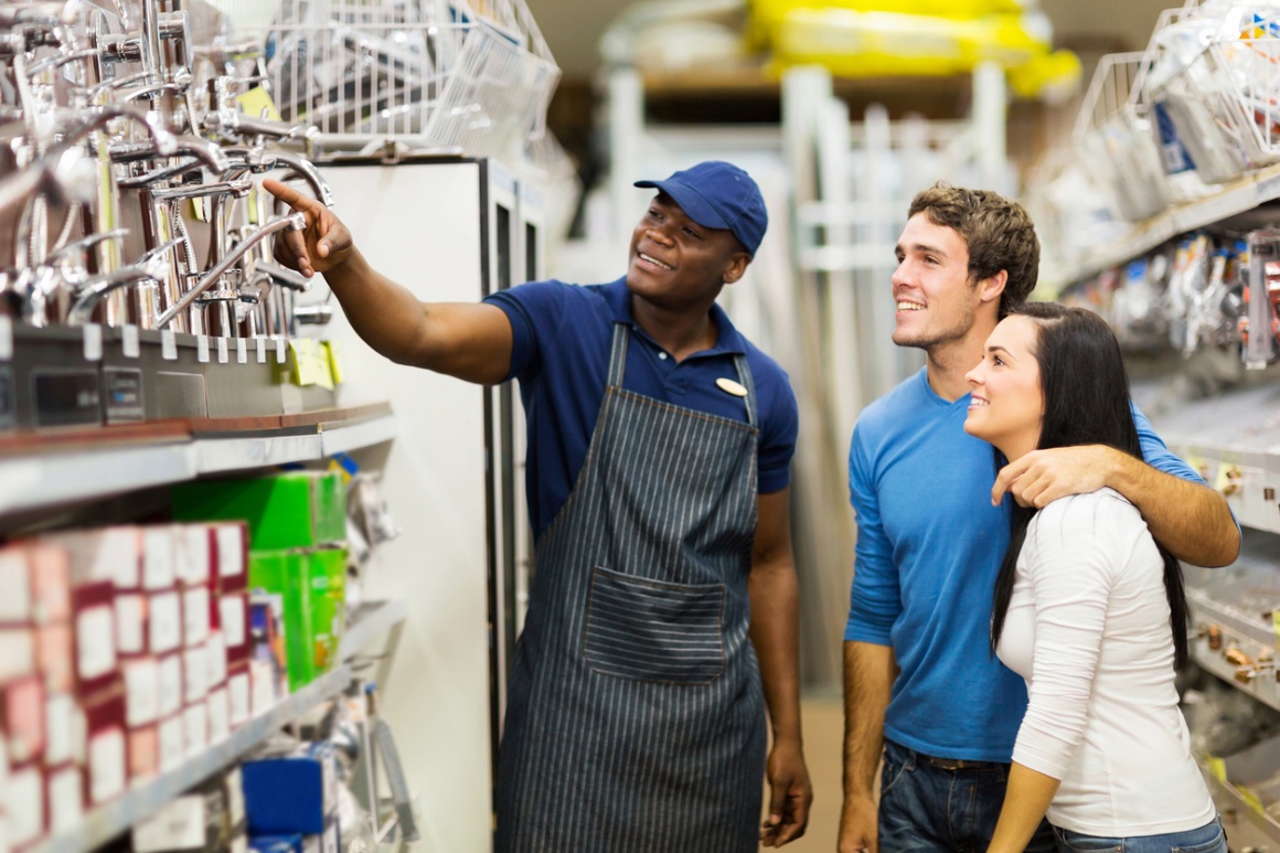 Employee shows customers products in a shelf