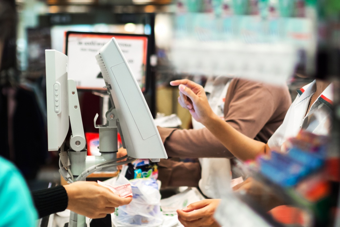 Photo: Cashiers and customers at checkout terminals with screens; copyright:...