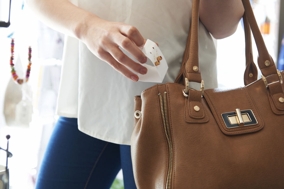 Photo: Customer puts earrings in her handbag; copyright: panthermedia. net /...