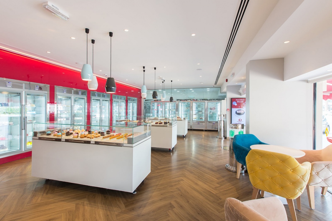 Photo: Modern bakery with counters, refrigerated shelves and seating areas;...