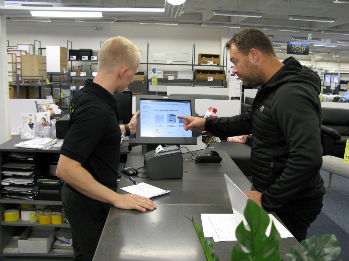 Photo: Employee shows a customer product information on a screen at...