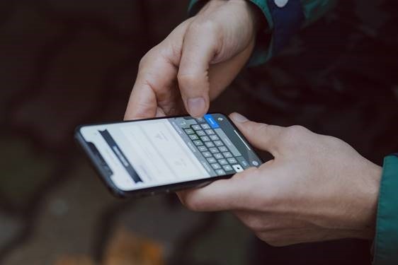 Person typing on smartphone; copyright: Kisi