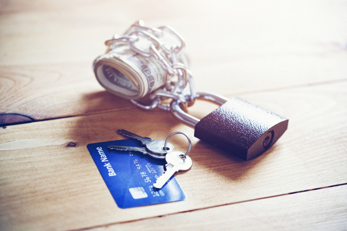 Banknotes secured by a lock and a credit card with keys; copyright:...