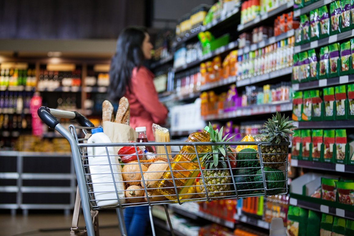 Shopping cart filled with groceries in a supermarket; copyright:...