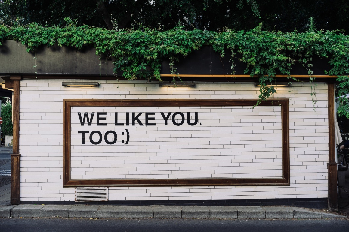 Sign on a wall with text we like you too; Copyright: Adam Jang/Unsplash...