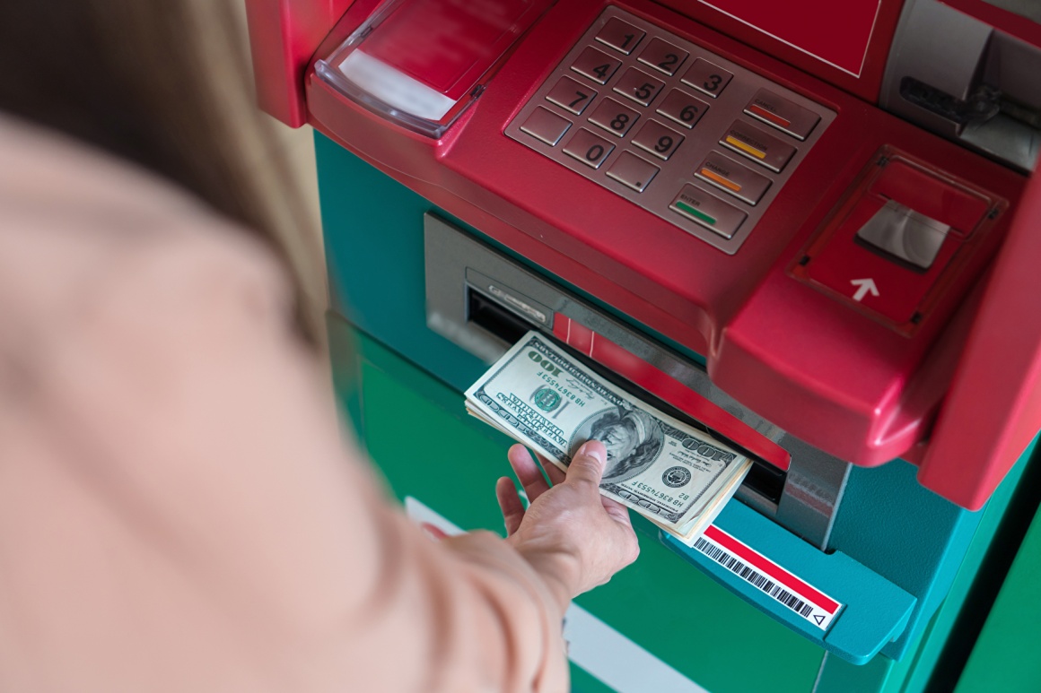 Woman taking bank notes from an ATM; copyright: panthermedia.net/Tzido...