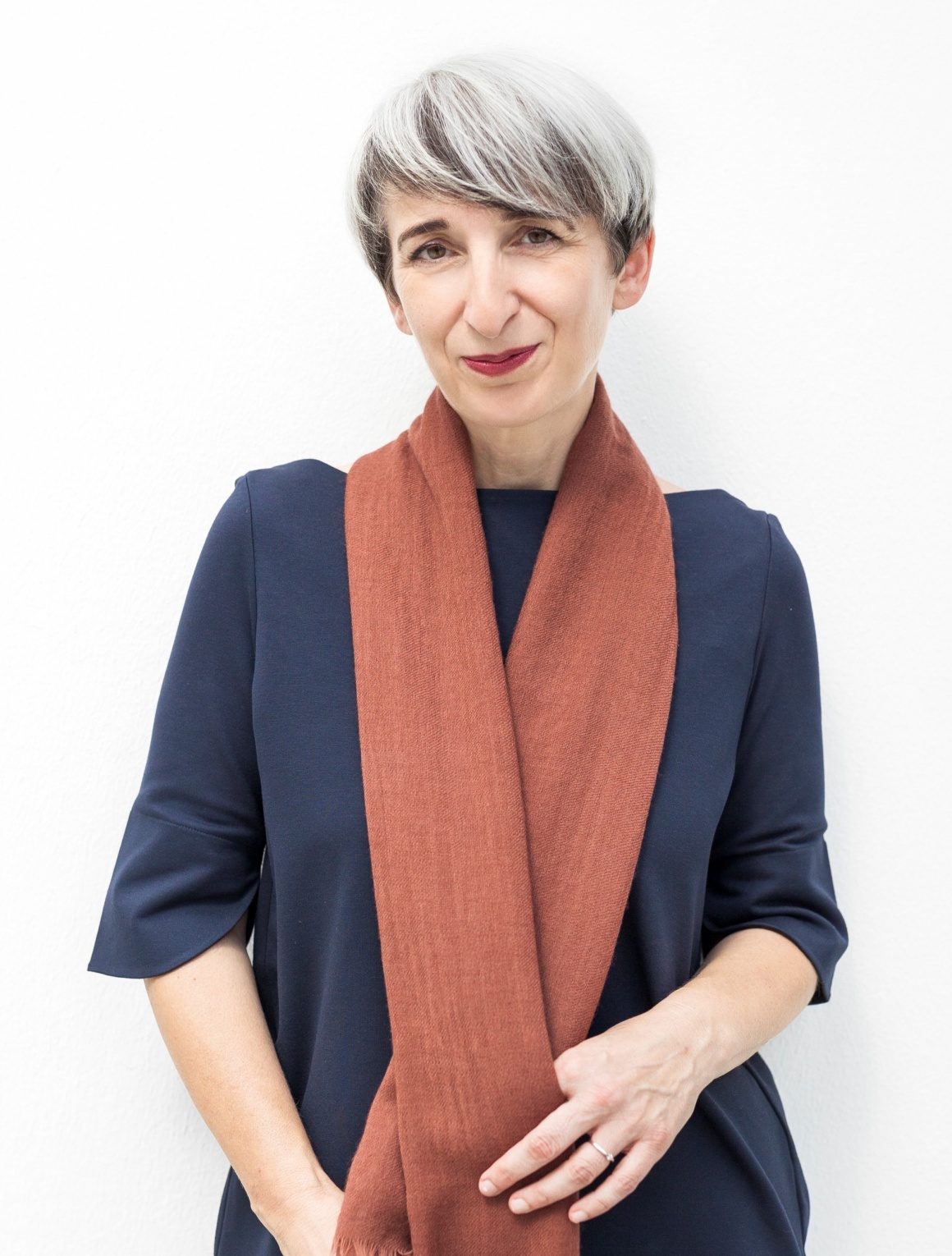 A smiling woman with a long red scarf