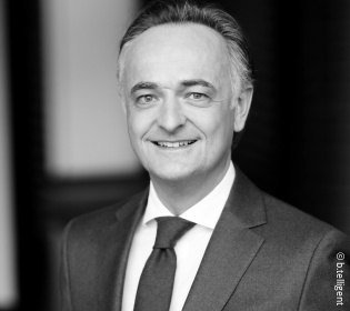 Black and white picture of a smiling man in a suit....