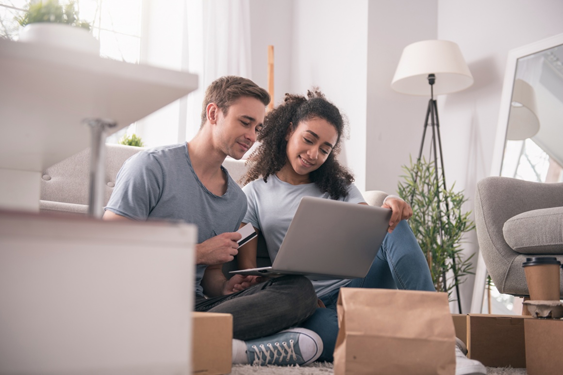 Two people sitting on the floor and looking at a laptop....