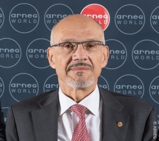 Man with glasses smiling in front of the camera