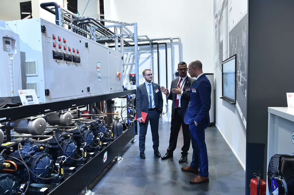 Men standing in front of refrigeration system