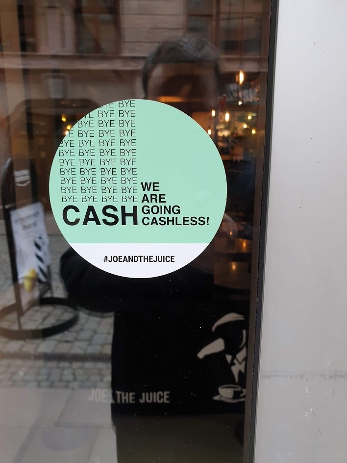 Sign on a glass door with the inscription We are going cashless....