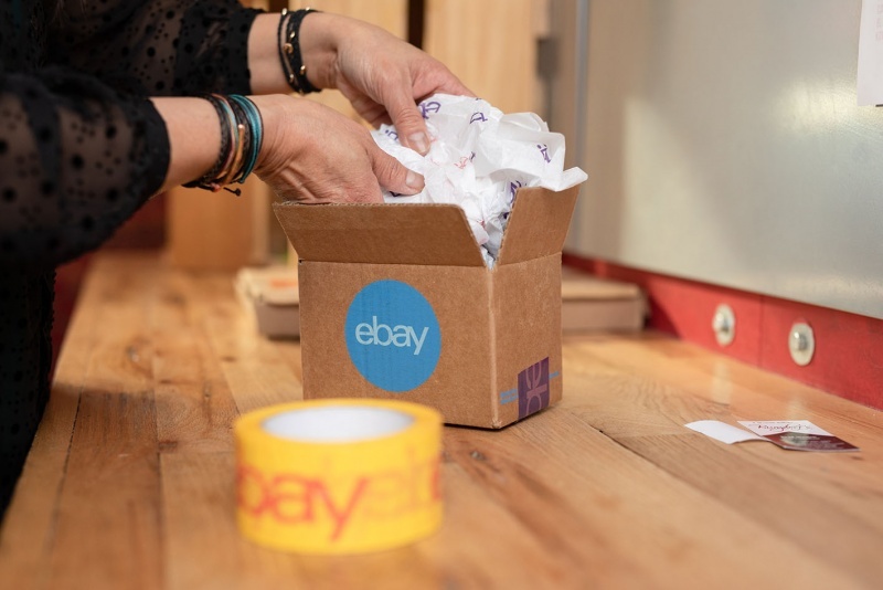 Hands taking packaging material out of a small package; copyright: eBay...