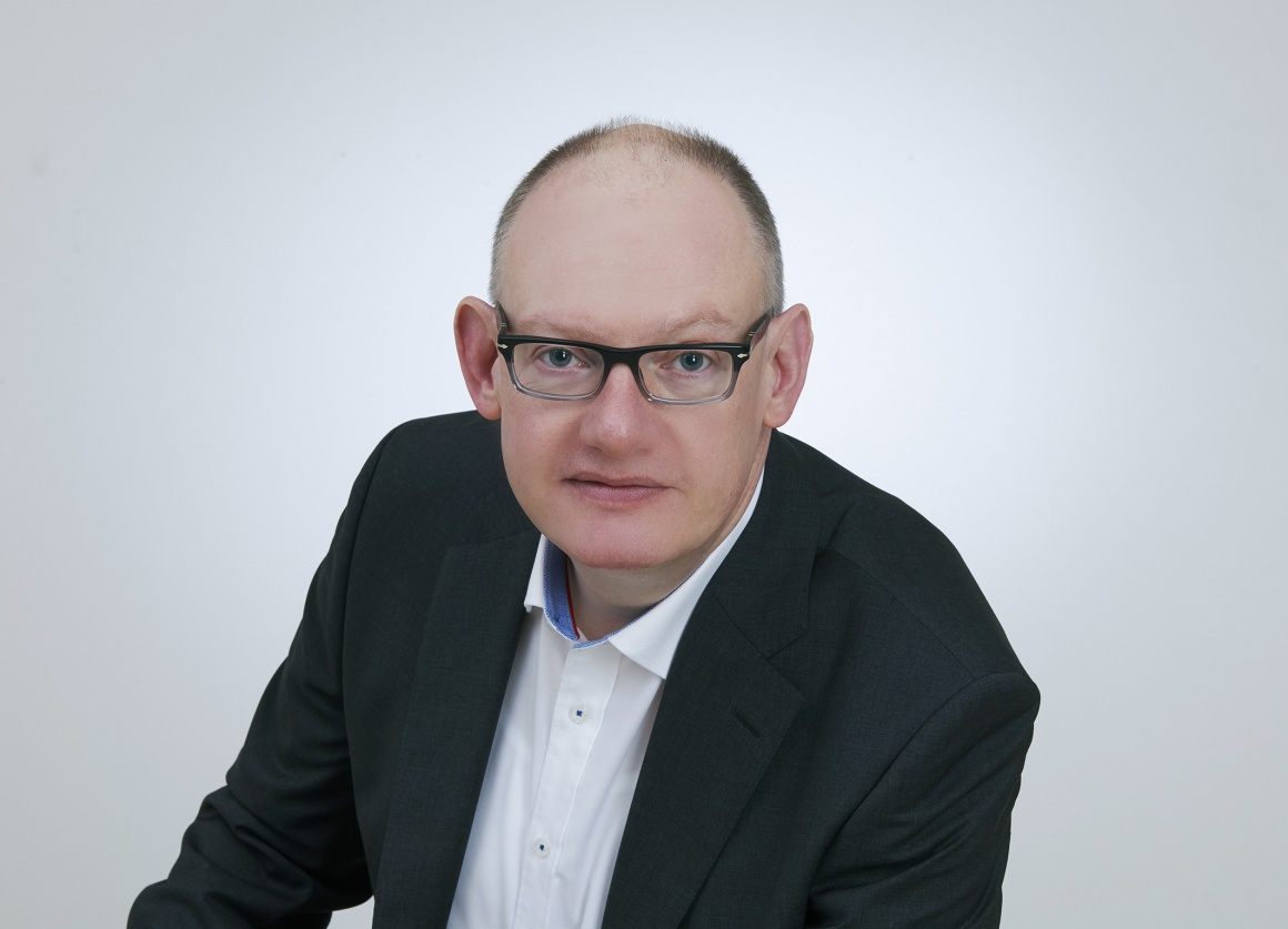 Man with glasses wearing a suit and looking into the camera...